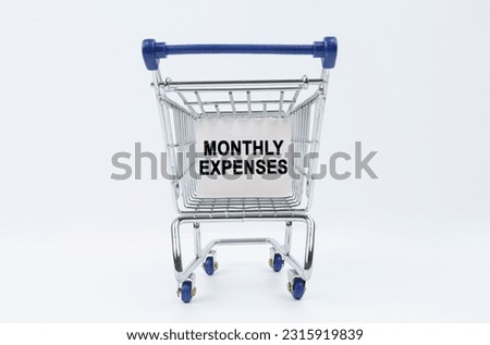 Business concept. On a white background is a shopping cart with a sign that says - monthly expenses