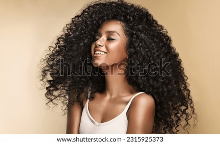 Beauty portrait of african american girl with clean healthy skin on beige background. Smiling dreamy beautiful black woman.Curly  hair in afro style  Royalty-Free Stock Photo #2315925373