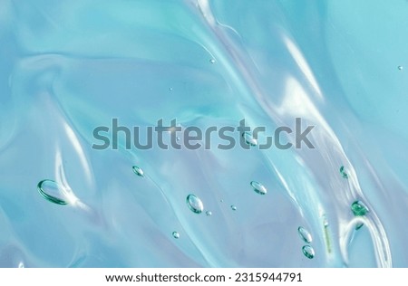 Gel texture of cosmetic products. transparent cream on a blue pink background with bubbles. macro photo. blur and selective focus