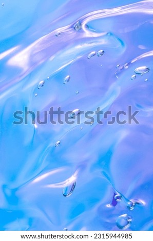 Gel texture of cosmetic products. transparent cream on a blue background with bubbles. macro photo. blur and selective focus. Vertical photo