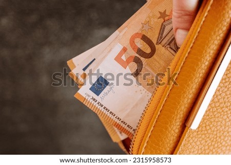 money in wallet. Counting money. hand takes out euro bill from the wallet. Earnings and spending in the Eurozone. Royalty-Free Stock Photo #2315958573