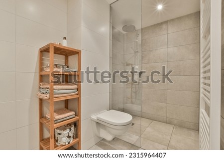 a bathroom with a toilet, shower and shelves on the wall in front of the bathtub that is made out of wood Royalty-Free Stock Photo #2315964407