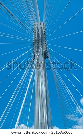 Modern bridge pylon against a blue sky. Detail of the multi-span cable-stayed bridge. Linear perspective view of a white cable-stayed suspension Alex Fraiser Bridge in BC. Nobody, selective focus Royalty-Free Stock Photo #2315966003