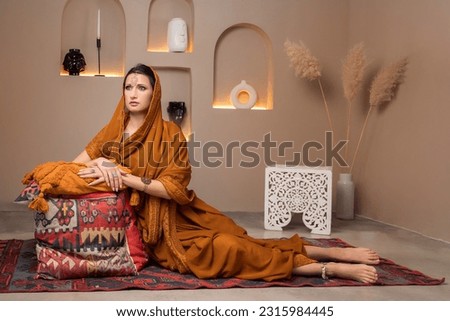 a young beautiful Indian woman in a photo studio, serves on pillows, selective focus.