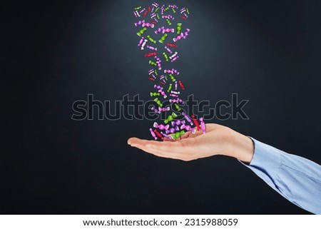 picture of woman's hand on a black background with candies falling from above down on hand Suitable for use in food media and advertising media.