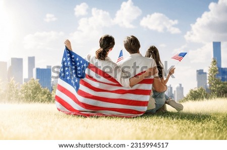 Patriotic holiday. Happy family, parents and daughter child girl with American flag outdoors. The USA celebrate 4th of July. Royalty-Free Stock Photo #2315994517