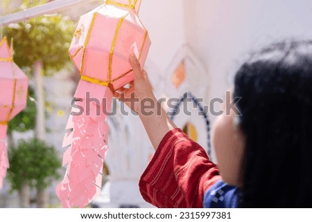 Lanna Paper cust Art or Tung lantren in Asian woman hand for a celebration in the northern temple in Thailand. Selective focus. Royalty-Free Stock Photo #2315997381