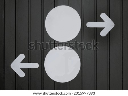 White right and left arrow acrylic sign with white circles sign on black wooden background. Dicision concept