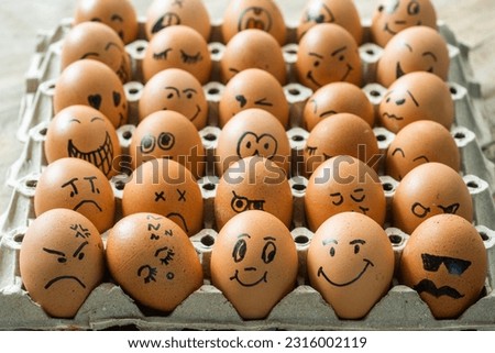 Eggs with many emotions in pit tray isolated on white background.Chicken eggs with drawn face emotions,Easter eggs in a tray with a smile