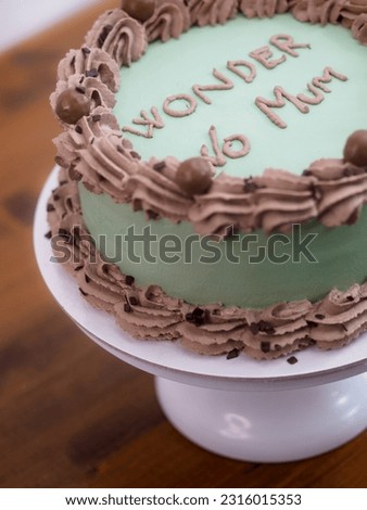 frosted icing elegant cake with funny lettering topping. Mother s day celebration cupcake. Humor in food concept. Family love. Royalty-Free Stock Photo #2316015353
