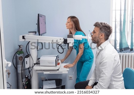 Man testing breathing function by spirometry. Diagnosis of respiratory function in pulmonary disease Royalty-Free Stock Photo #2316034327