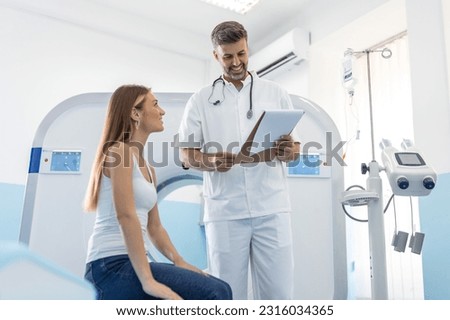 Male doctor giving information to woman before MRI scan examination. Magnetic resonance imaging technology in specialized medical clinic.