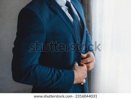 Business and serious man businessman in white shirt, blue tie and suit stands at the window. Royalty-Free Stock Photo #2316044031