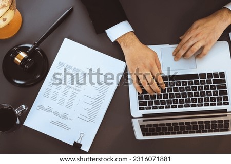 Top view lawyer or judge working on his desk with laptop at law firm or court, drafting legal documents with fairness and ethical judgment for lawsuits and litigation. Equilibrium Royalty-Free Stock Photo #2316071881