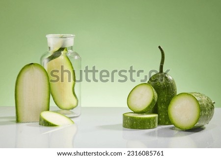 Creative background for advertising cosmetic with ingredient from winter melon. Some slices of winter melon and lab glassware decorated on a light green background. Space to place your product Royalty-Free Stock Photo #2316085761