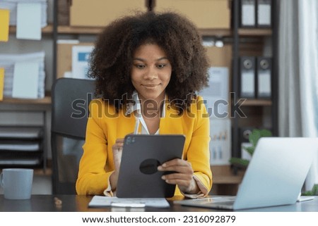 African American businesswoman working with tablet computer and finance marketing chart, Advisor showing plan of investment to clients at table office. Digital marketing online concept.