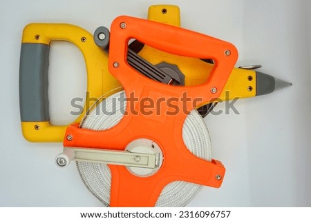 Orange and yellow tape measure in the photo on the white background