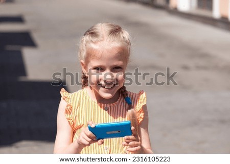 Smiling girl takes a photo or shoots a video on a smartphone, travel in summer.