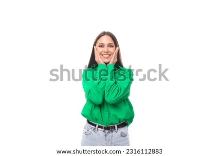 portrait of a confident smiling young european brown-eyed female model with well-groomed black hair and makeup dressed in a green shirt Royalty-Free Stock Photo #2316112883
