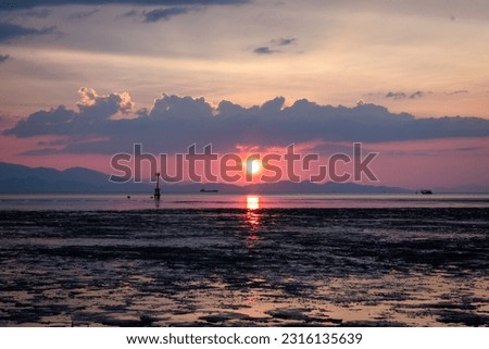 Beautiful sunset at the sea gate. Beautiful dawn over the sea, dramatic sky and light reflection on the water, sea view.