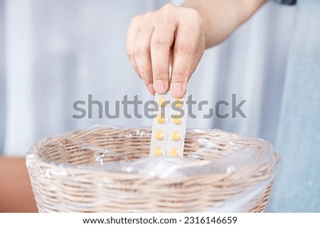 closeup Woman's Hand Disposing of Expired Medicine in Bin Royalty-Free Stock Photo #2316146659