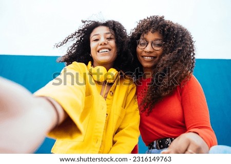 Young happy women taking selfies with the smartphone. Teenagers having fun outdoor after school