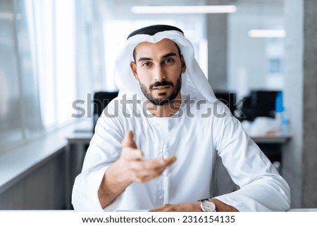 handsome man with dish dasha working in his business office of Dubai. Portraits of a successful businessman in traditional emirates white dress. Concept about middle eastern cultures Royalty-Free Stock Photo #2316154135