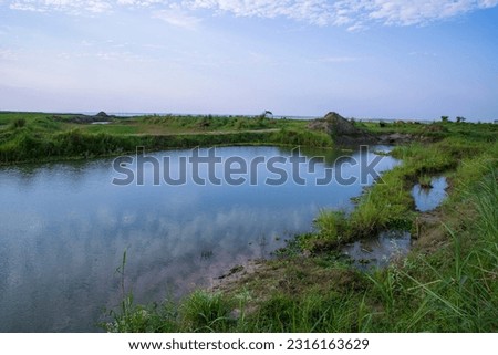 Lake water with green grass landscape view of under the blue sky