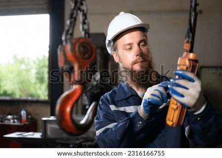 Technicians inspecting and testing the operation of lifting cranes in heavy industrial plants. Royalty-Free Stock Photo #2316166755