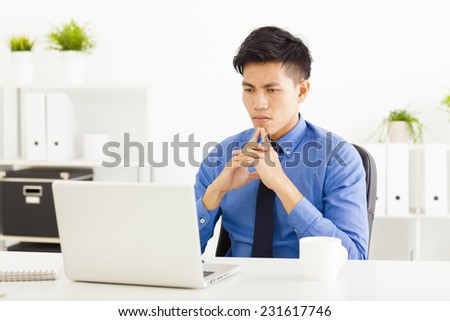 Young asian businessman watching laptop and thinking