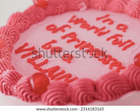 Pink frosted icing elegnt cake with funny lettering topper. Celebration cupcake. Humor in food concept. Be strong be bad. Royalty-Free Stock Photo #2316183165