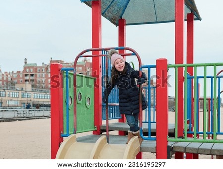 young girl playing at a beach playground