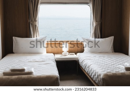 Bedroom with interior of double passenger cabin ferry ship with ocean view. Royalty-Free Stock Photo #2316204833