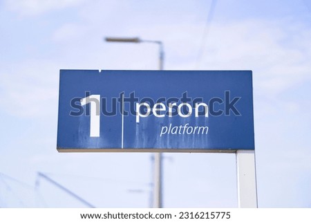 Polish sign indicating the platform number on a blue board with smudged lettering   
