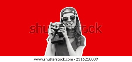 Portrait of happy smiling young woman photographer taking picture on film camera wearing red baseball cap on red background, magazine style