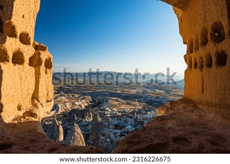 Hot air balloon flying over Goreme National Park seen from Uchisar Castle in Cappadocia, Turkey