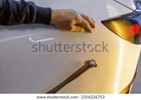 Removal of dents without painting. PDR technology for car body repair. PDR. The mechanic at the auto shop with tools to repair dents in car body. Body repair.
 Royalty-Free Stock Photo #2316226753