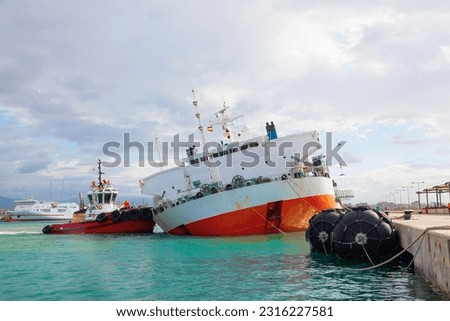 The transport ship sinks in the port of Palma de Mallorca, and the tug rescues. Royalty-Free Stock Photo #2316227581