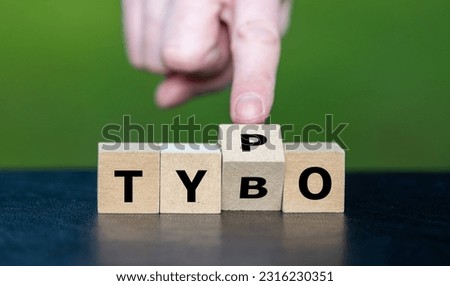 Symbol for correcting a typo. Hand turns dice and corrects the expression tybo to typo. Royalty-Free Stock Photo #2316230351