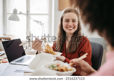 Young colleagues having lunch time in their office. Royalty-Free Stock Photo #2316237113
