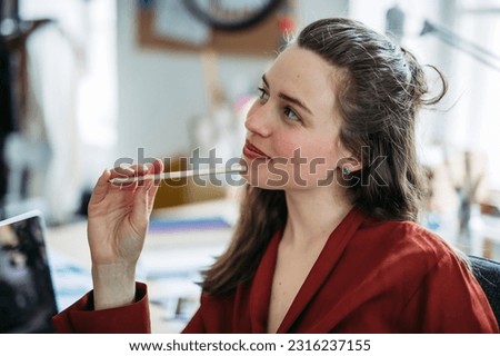 Portrait of funny woman with pencil, having fun at work.