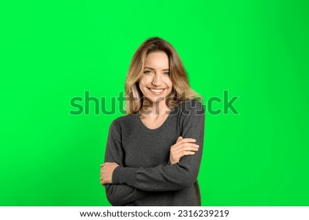 Chroma key compositing. Pretty young woman smiling against green screen