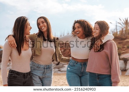 Four multiracial young happy girls hugging after reunion on the beach. Royalty-Free Stock Photo #2316240903