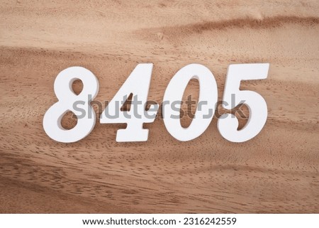 White number 8405 on a brown and light brown wooden background.