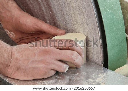 A closeup of traditional wood artist at work smoothing the timber