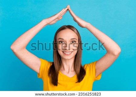 Photo of cheerful young lady hands roof look camera wear shirt isolated over blue color background.