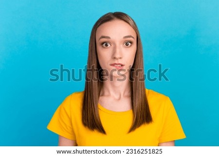 Photo of unsure upset young lady dressed t-shirt biting lip isolated blue color background.