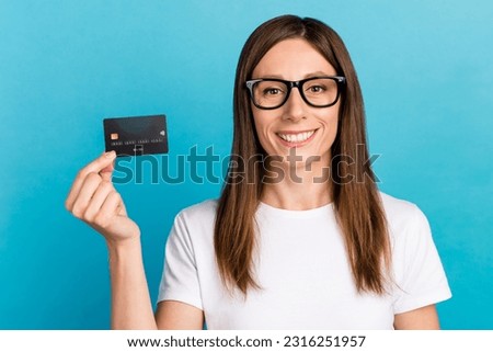 Photo of cheerful lady hold debit card look isolated blue color background.