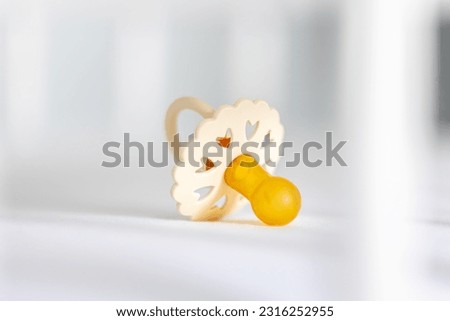 Baby's pacifier on a blurred white background.