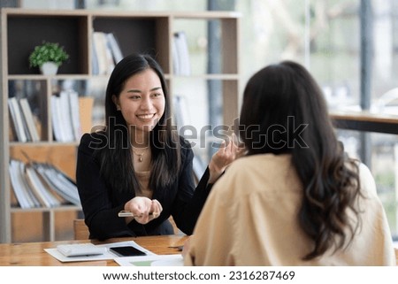 Two asian businesswoman sitting and consulting business inside modern office Royalty-Free Stock Photo #2316287469
